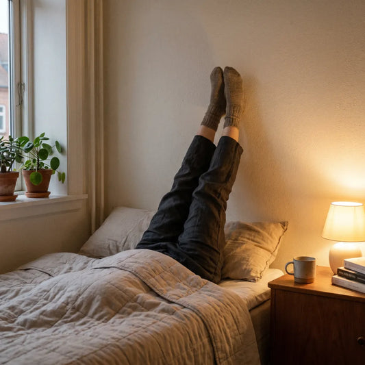 Femme jambes relevées contre le mur en routine du soir — jambes légères au réveil